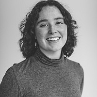 A black and white photo of McKenna, smiling at the camera.