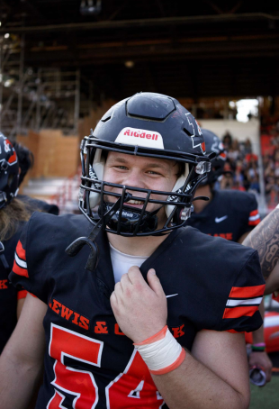 Wil smiling at the camera, wearing a football helmet and his L&C football uniform.