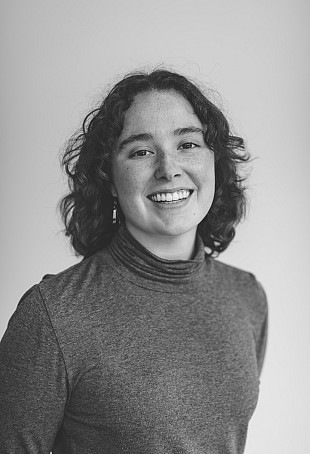 A black and white photo of McKenna, smiling at the camera.