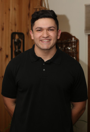 Luke smiling, wearing a black polo shirt.