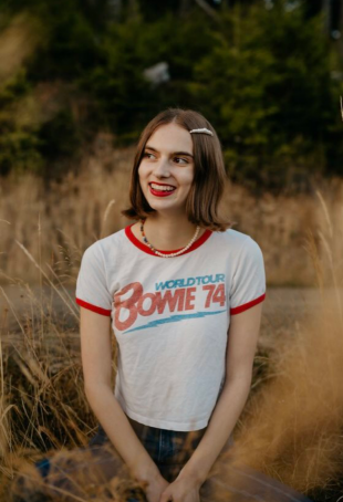 Annabelle smiling outside wearing a white t-shirt.