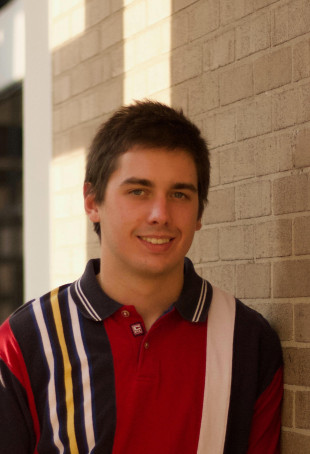 Justin smiling at the camera, wearing a black and red striped shirt.