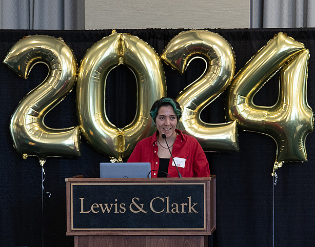 Indigo speaking at IME banquet with 2024 balloons floating in the back