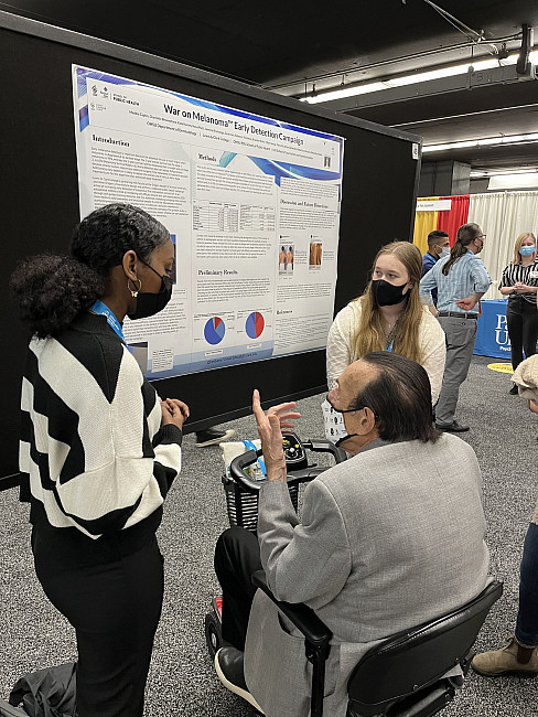 Labbies presenting research to Dr. Zimbardo at WPA 2022