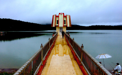 Student walking on a bridge toward a building.