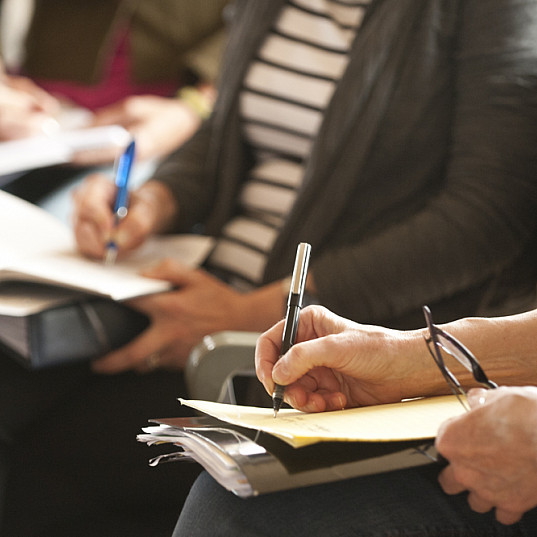 Close up of people writing on paper.