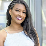 Demaris wearing a white tank top, smiling