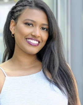 Demaris wearing a white tank top, smiling