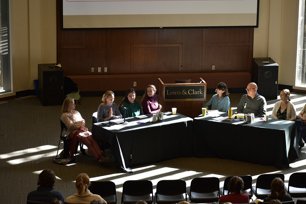 8 people seated as panelists at tables