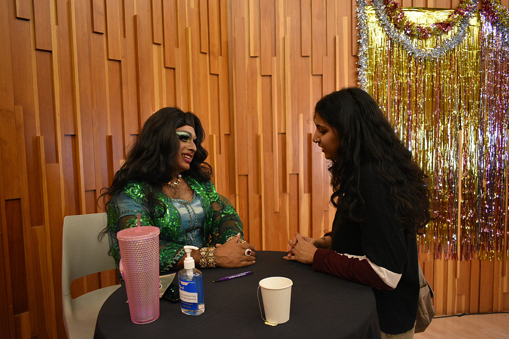 drag queen speaking with student at table