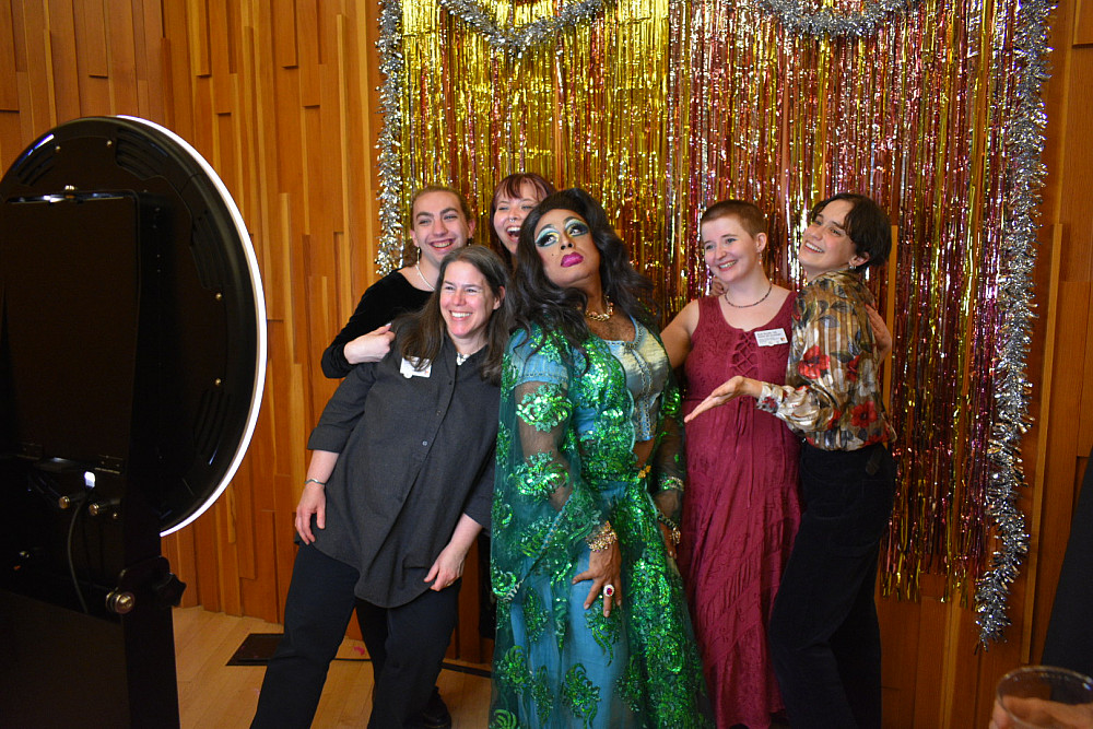 4 people posing in photo booth with drag queen