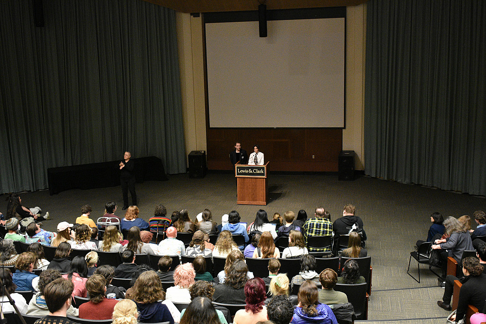 2 people standing at podium addressing audience