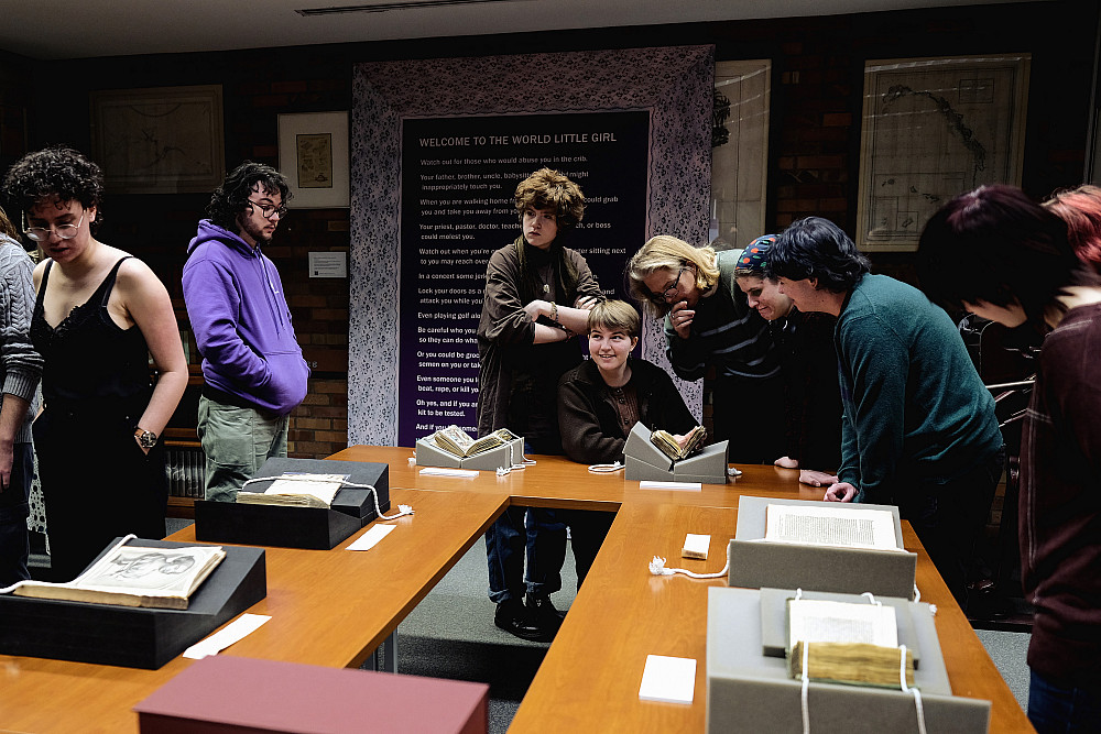 Students viewing items from library special collections on tables.