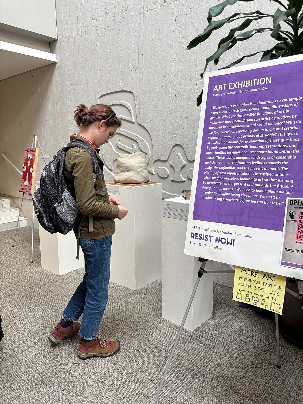 person observing art on pedestals.