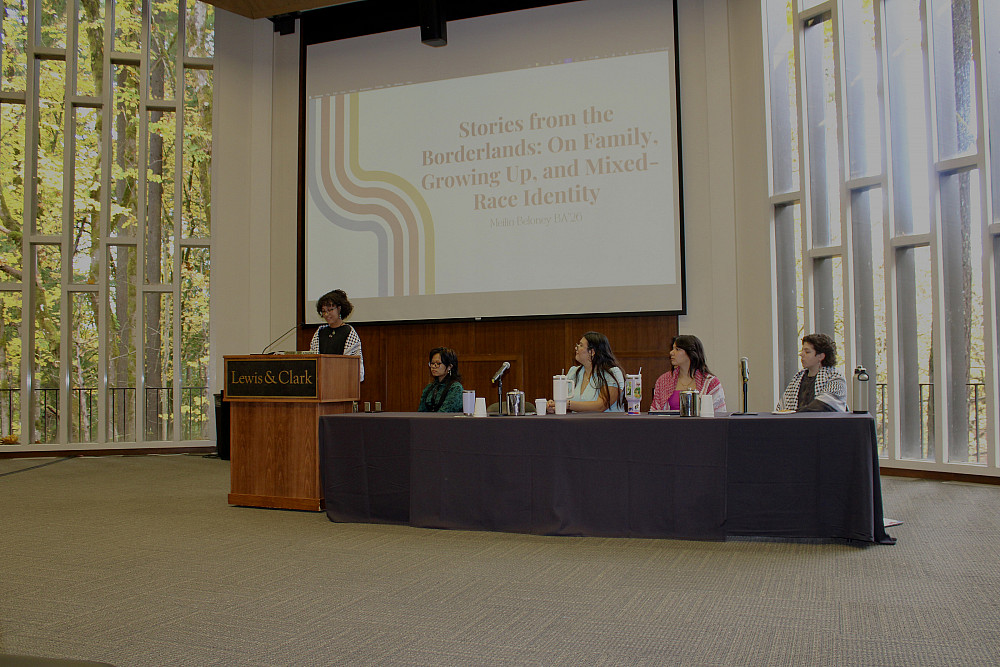 Student standing at the podium in Council Chambers, presenting their research