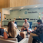 A group of people sitting in a lobby together.