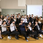 Large group of students all pointing at the camera.