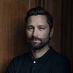 Headshot of Quinn, posing with his arms crossed.