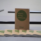 Brown journal with the words respect. writing. community in a green circle on the cover.