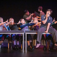 Students performing a play on a stage.
