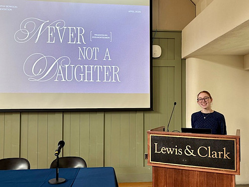 Student standing behind a posium with large screen in background