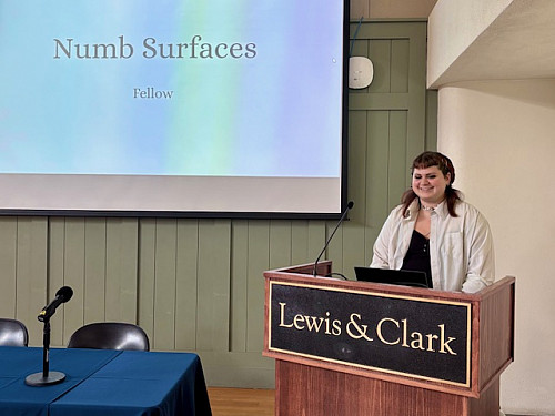 Student at podium with large screen in background