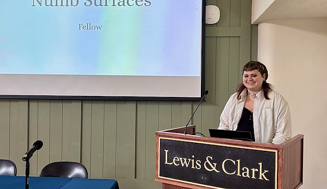 Student at podium with large screen in background